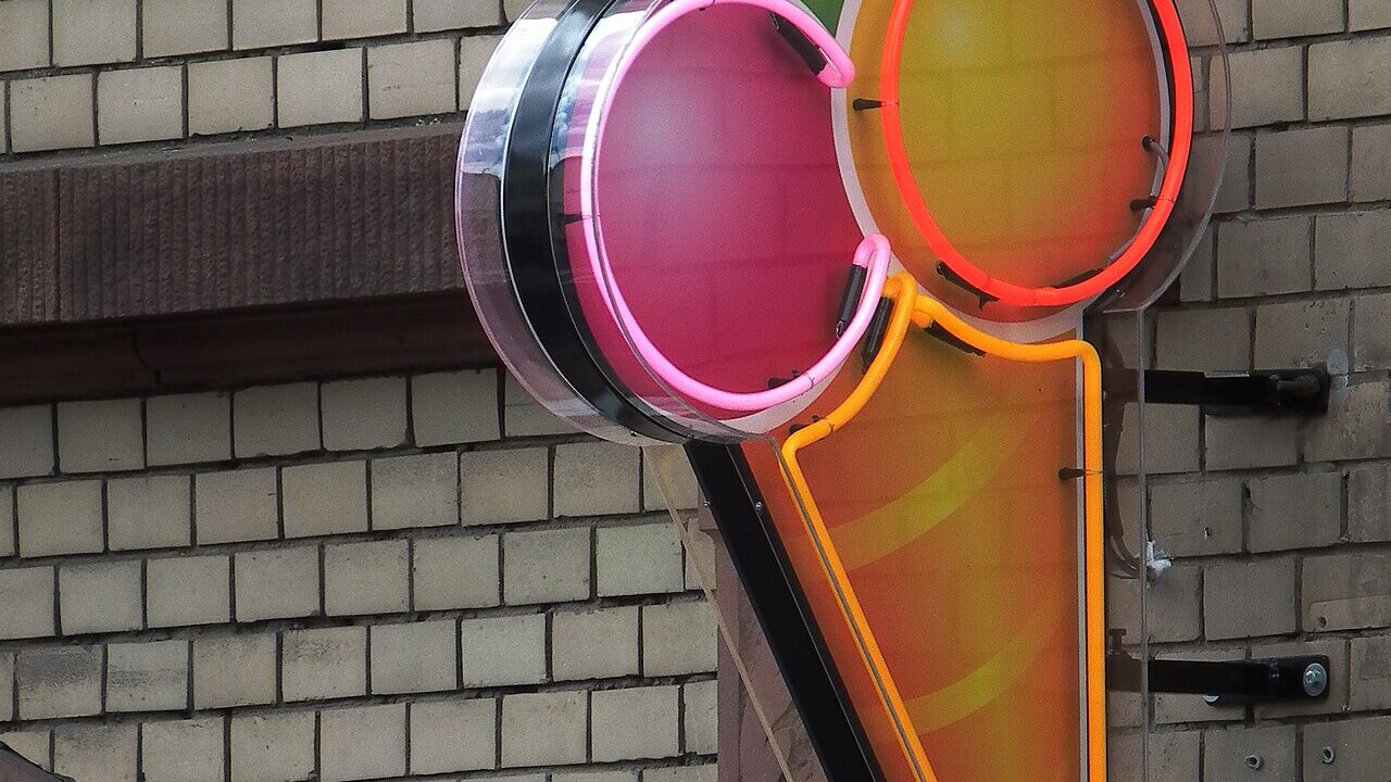 Leuchtreklame in Form einer Eistüte an einer Eisdiele